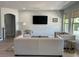 Living room with modern decor, flat-screen TV, comfortable seating, and view to the outdoors at 302 Coco Plum Ct, Oldsmar, FL 34677