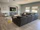 A well-lit living room boasts a large sectional sofa, media console, a patterned area rug, and light gray floors at 302 Coco Plum Ct, Oldsmar, FL 34677