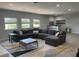 Open-concept living room featuring a sectional sofa, bright windows, bar area, and a stylish patterned area rug at 302 Coco Plum Ct, Oldsmar, FL 34677