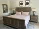 Comfortable main bedroom with a rustic wood bed frame, lamps, and matching nightstands at 302 Coco Plum Ct, Oldsmar, FL 34677