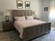 Main bedroom featuring a rustic wood bed frame, lamps, and matching nightstands at 302 Coco Plum Ct, Oldsmar, FL 34677