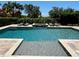 Beautiful backyard pool with integrated spa, deck chairs and private landscaping at 302 Coco Plum Ct, Oldsmar, FL 34677