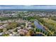 Aerial view of a home on the water featuring a screened-in pool, solar panels, and mature trees at 1913 Blue River Rd, Holiday, FL 34691