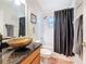 Bathroom featuring stylish vanity with a bronze vessel sink and a tiled walk-in shower at 1913 Blue River Rd, Holiday, FL 34691