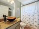 Bathroom showcasing a vessel sink, decorative mirror, and a shower/tub combination with an elephant-patterned curtain at 1913 Blue River Rd, Holiday, FL 34691