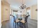 Bright dining room featuring a chandelier, views to the living room and pool, and decorative wood-look flooring at 1913 Blue River Rd, Holiday, FL 34691
