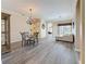 Open-concept dining room featuring a glass table, modern chandelier, and beautiful wood-look flooring at 1913 Blue River Rd, Holiday, FL 34691