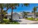 Charming single-story home featuring a three-car garage, a well-manicured lawn and mature trees and landscaping at 1913 Blue River Rd, Holiday, FL 34691
