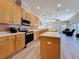 Kitchen with stainless steel appliances, island, and views into the living room at 1913 Blue River Rd, Holiday, FL 34691