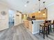 Kitchen with stainless steel appliances and seating at the breakfast bar, plus gray wood-look floors at 1913 Blue River Rd, Holiday, FL 34691