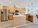 Kitchen with stainless steel appliances and island, plus gray wood-look floors at 1913 Blue River Rd, Holiday, FL 34691