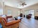 Living room with ceiling fan, access to outdoor patio, and two chairs and sofa at 1913 Blue River Rd, Holiday, FL 34691