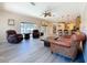 Spacious living room with backyard access, two chairs, sofa and kitchen view at 1913 Blue River Rd, Holiday, FL 34691