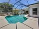 Serene pool within a screened lanai, featuring a swinging chair and tropical plants for a relaxing retreat at 1913 Blue River Rd, Holiday, FL 34691