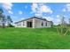 Modern home exterior with a lush lawn, a sliding glass door, and a sleek design at 1486 Ardisia St, North Port, FL 34288