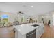 Modern kitchen island with stainless steel appliances and sink that opens up to the living and dining areas at 1486 Ardisia St, North Port, FL 34288