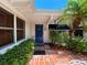 Charming front entrance with brick flooring, manicured greenery, and a vibrant blue door at 16107 Gulf Blvd, Redington Beach, FL 33708