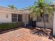 Inviting front patio with brick flooring, lush greenery, and a charming seating area near the entryway at 16107 Gulf Blvd, Redington Beach, FL 33708