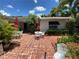 Quaint brick patio with outdoor seating, shaded by palm trees, ideal for enjoying the outdoors at 16107 Gulf Blvd, Redington Beach, FL 33708