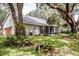 Exterior showcasing a house with a screened porch and a lush backyard featuring mature trees at 2906 Country Breeze Dr, Plant City, FL 33567