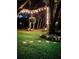 Nighttime view of a beautifully landscaped yard with string lights and mature trees, creating a magical ambiance at 2906 Country Breeze Dr, Plant City, FL 33567