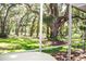 Spacious backyard with lush lawn, mature trees, and a screened-in porch offering serene outdoor living at 2906 Country Breeze Dr, Plant City, FL 33567