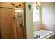 This bathroom features a tiled shower, a drop in tub, and neutral color tile throughout at 2906 Country Breeze Dr, Plant City, FL 33567