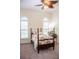 This bedroom features a four poster bed, neutral walls, and two windows with a ceiling fan at 2906 Country Breeze Dr, Plant City, FL 33567