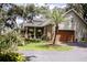 Exterior shot of home and garage, showcasing a covered porch, mature trees, landscaping and a neutral color palette at 2906 Country Breeze Dr, Plant City, FL 33567