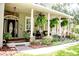 Charming front porch with ferns, columns and stone accents, offers a welcoming entrance to this beautifully landscaped home at 2906 Country Breeze Dr, Plant City, FL 33567