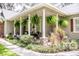 Inviting front porch with elegant columns, hanging ferns and manicured landscaping creates a tranquil outdoor space at this home at 2906 Country Breeze Dr, Plant City, FL 33567