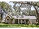 Charming single-story home with stone accents, dormers and a welcoming front porch, surrounded by mature trees and lush landscaping at 2906 Country Breeze Dr, Plant City, FL 33567