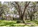 Beautiful single-story home with a stone exterior and inviting front porch, set amidst mature trees and a well-manicured lawn at 2906 Country Breeze Dr, Plant City, FL 33567