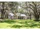 Single-story home with stone accents, dormer windows and inviting front porch, with detached garage and mature tree shaded lawn at 2906 Country Breeze Dr, Plant City, FL 33567