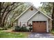 Detached garage with a rustic exterior, surrounded by mature trees and well-maintained landscaping, complementing the property at 2906 Country Breeze Dr, Plant City, FL 33567