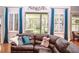 Inviting living room with plush leather seating, shuttered windows, and a view of the backyard at 2906 Country Breeze Dr, Plant City, FL 33567