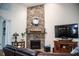 Living room showcasing a stone fireplace with a decorative mirror and a large TV at 2906 Country Breeze Dr, Plant City, FL 33567
