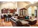 Open-concept living space with leather furniture, hardwood floors, and kitchen access at 2906 Country Breeze Dr, Plant City, FL 33567