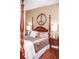 This main bedroom features a four poster bed, wood floors, and neutral decor at 2906 Country Breeze Dr, Plant City, FL 33567