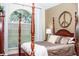 This main bedroom features a four poster bed, wood floors, and a large arched window at 2906 Country Breeze Dr, Plant City, FL 33567