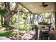 Relaxing screened-in porch with dining table, ceiling fan, and views of the lush, expansive backyard at 2906 Country Breeze Dr, Plant City, FL 33567