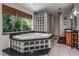 Elegant bathroom with a glass-blocked corner tub, a tropical view and dual vanities at 18620 Wayne Rd, Odessa, FL 33556