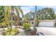 Charming home featuring lush tropical landscaping and a well-maintained two-car garage at 251 Tropic W Blvd, Largo, FL 33770