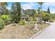 Well maintained front yard with lush landscaping, mature trees, and charming curb appeal at 251 Tropic W Blvd, Largo, FL 33770
