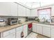 Well-lit kitchen features white cabinetry, neutral countertops and tiled floor at 251 Tropic W Blvd, Largo, FL 33770