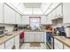 Well-lit kitchen features white cabinetry, a stainless steel stove and neutral countertops and tiled floor at 251 Tropic W Blvd, Largo, FL 33770