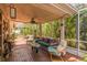 Cozy covered patio with brick flooring, comfortable seating, and screened enclosure at 251 Tropic W Blvd, Largo, FL 33770