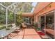 Outdoor brick patio with a screened enclosure surrounded by plants and offering comfortable seating at 251 Tropic W Blvd, Largo, FL 33770