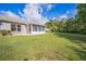 Scenic backyard featuring a large lawn, mature trees, and a screened-in patio for enjoying the outdoors at 2015 Gardenia Landings Ln, Sun City Center, FL 33573