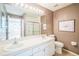 Bathroom featuring a double vanity, framed mirror, shower, toilet, and neutral wall paint at 2015 Gardenia Landings Ln, Sun City Center, FL 33573